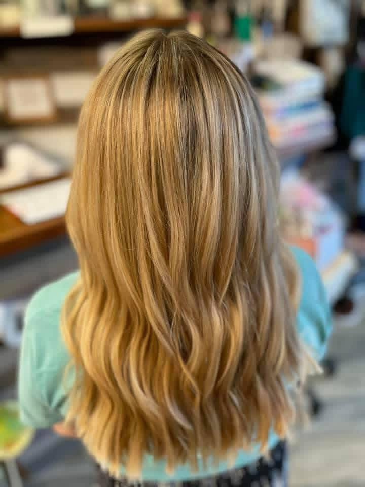 Warm dimensional hair color finished in soft waves